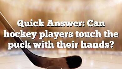 Quick Answer: Can hockey players touch the puck with their hands?
