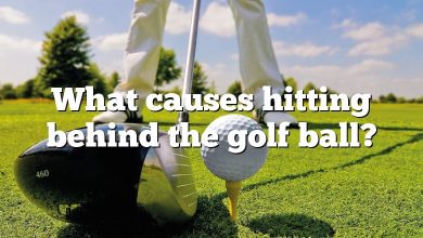 What causes hitting behind the golf ball?