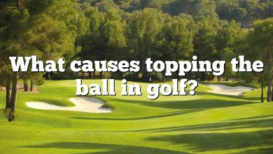What causes topping the ball in golf?