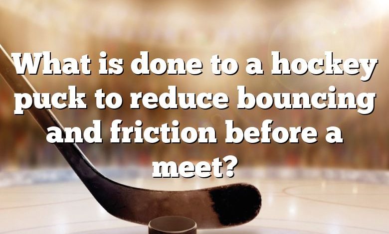 What is done to a hockey puck to reduce bouncing and friction before a meet?