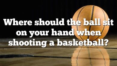 Where should the ball sit on your hand when shooting a basketball?