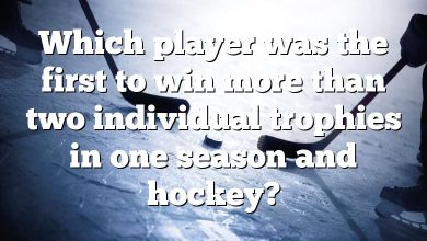 Which player was the first to win more than two individual trophies in one season and hockey?